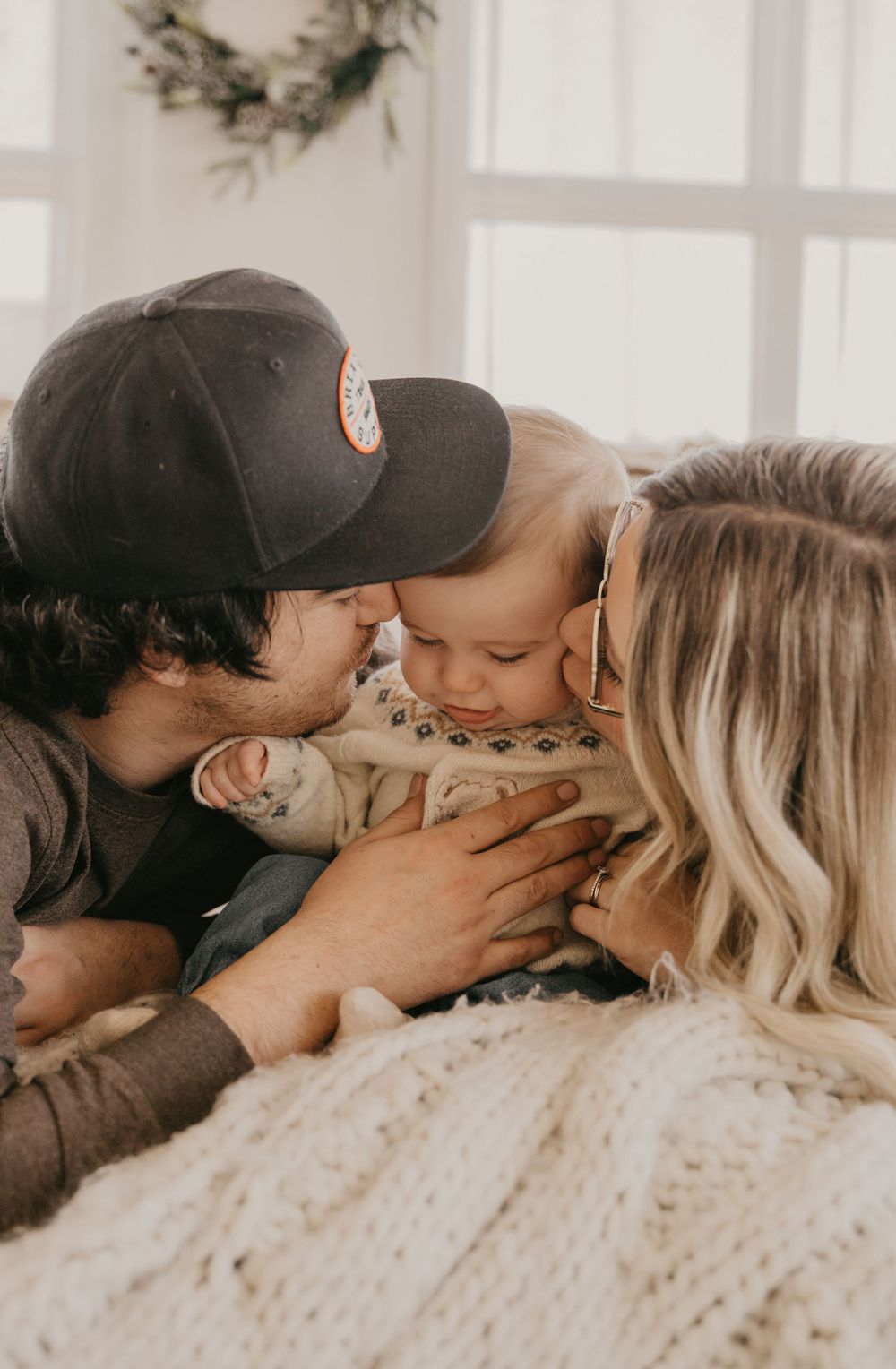 Family sharing intimate kisses and cuddles during a holiday photoshoot.