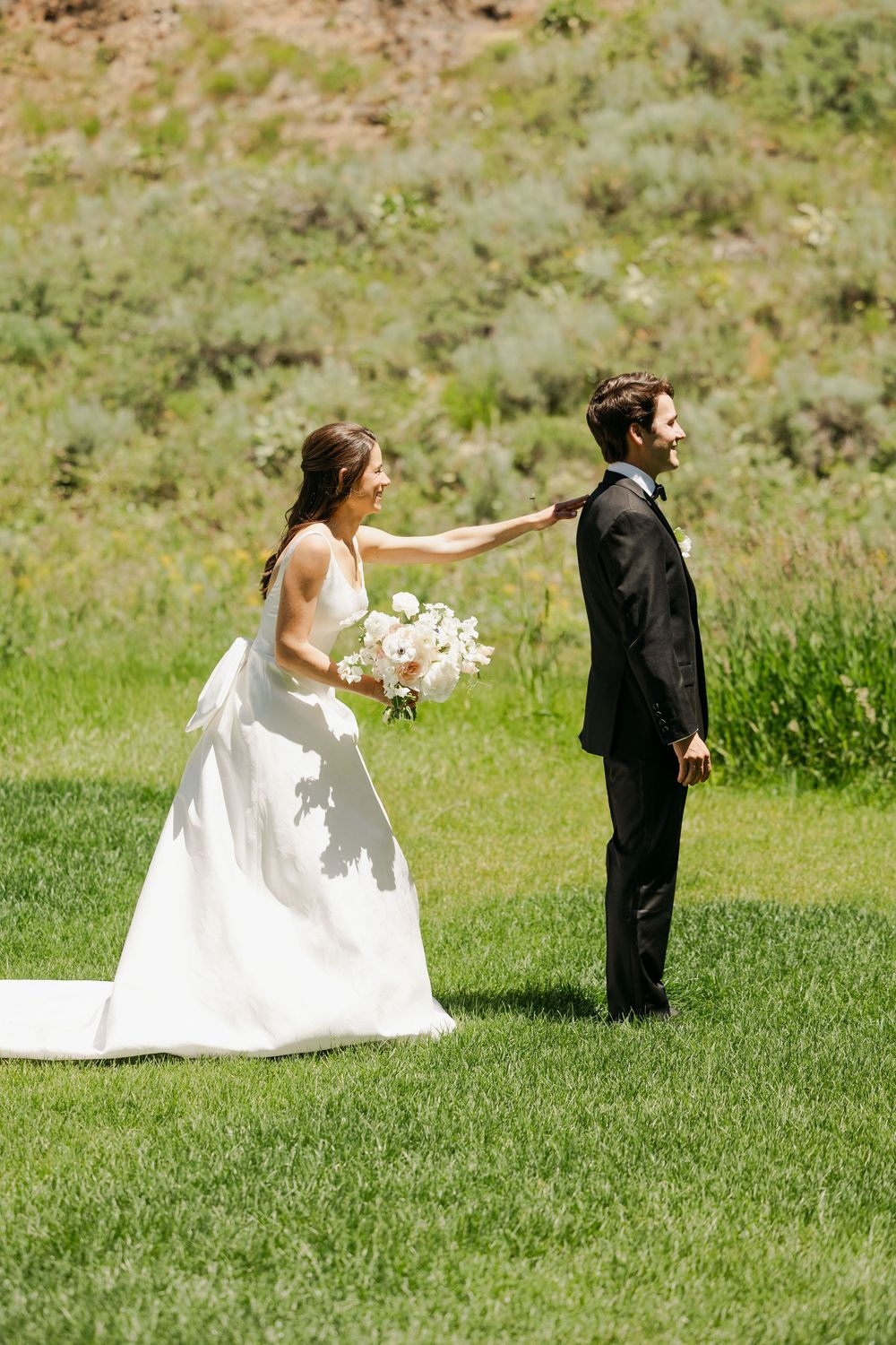 A sequence of photos showing a bride playfully chasing after someone in formal wear across a grassy hillside.