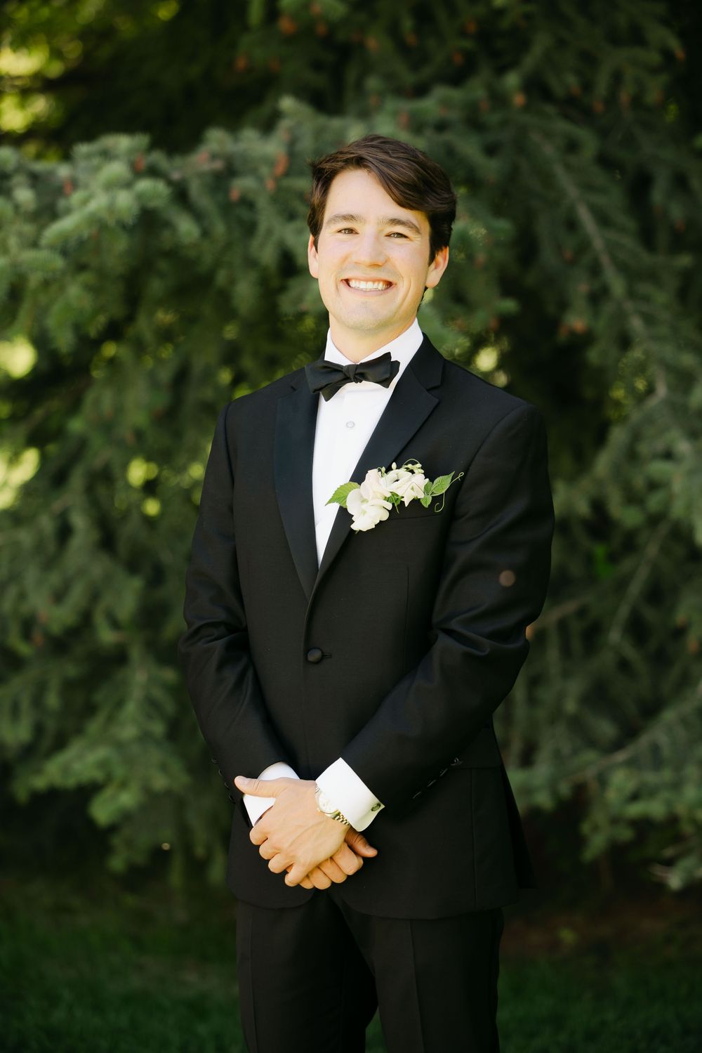 A series of formal wedding portraits showing someone in a classic black tuxedo with a boutonniere.
