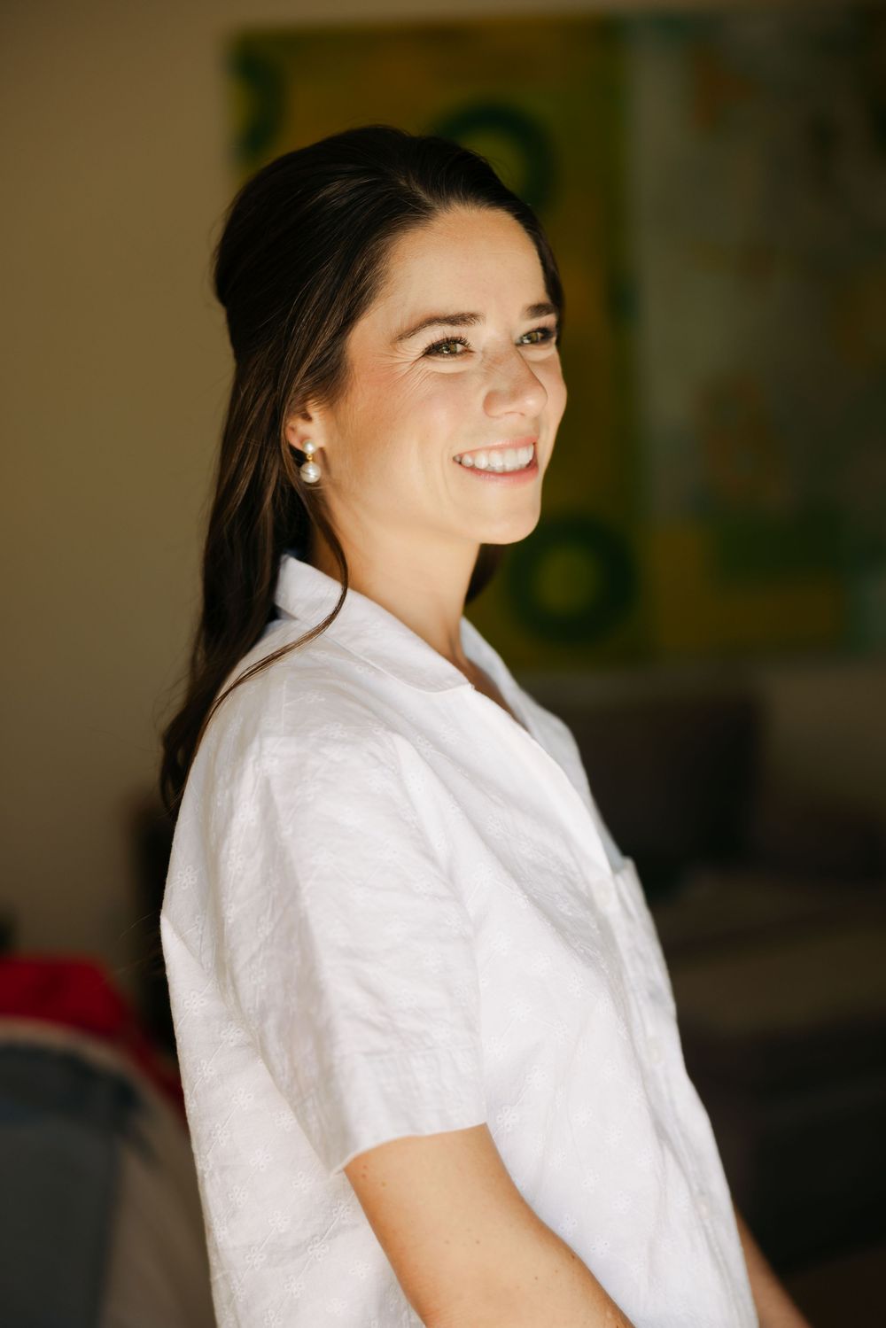 Candid sequence of someone in a white button-down shirt laughing joyfully against a blurred indoor background.