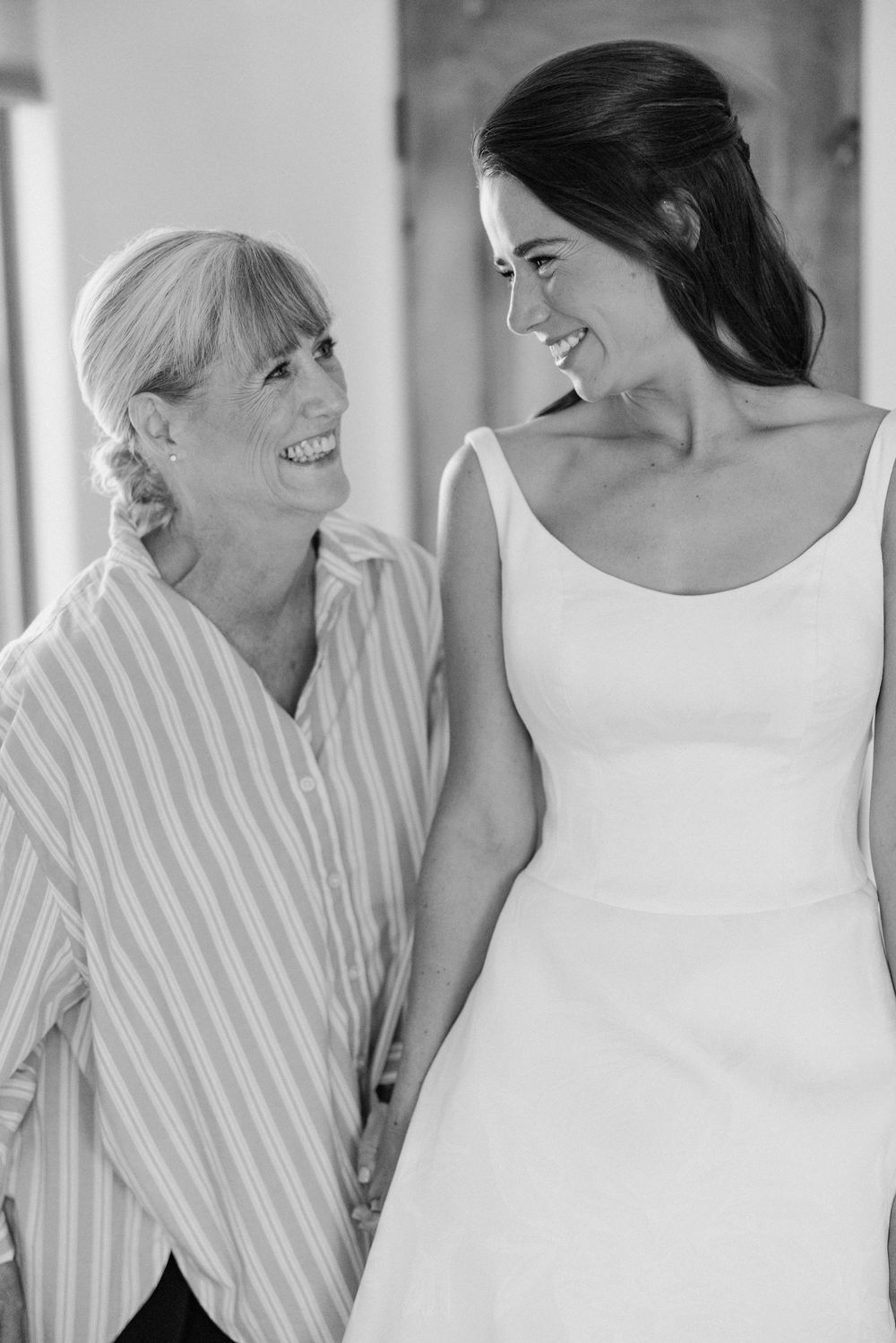 Black and white candid photos showing joyful interactions between people in a striped shirt and white dress.