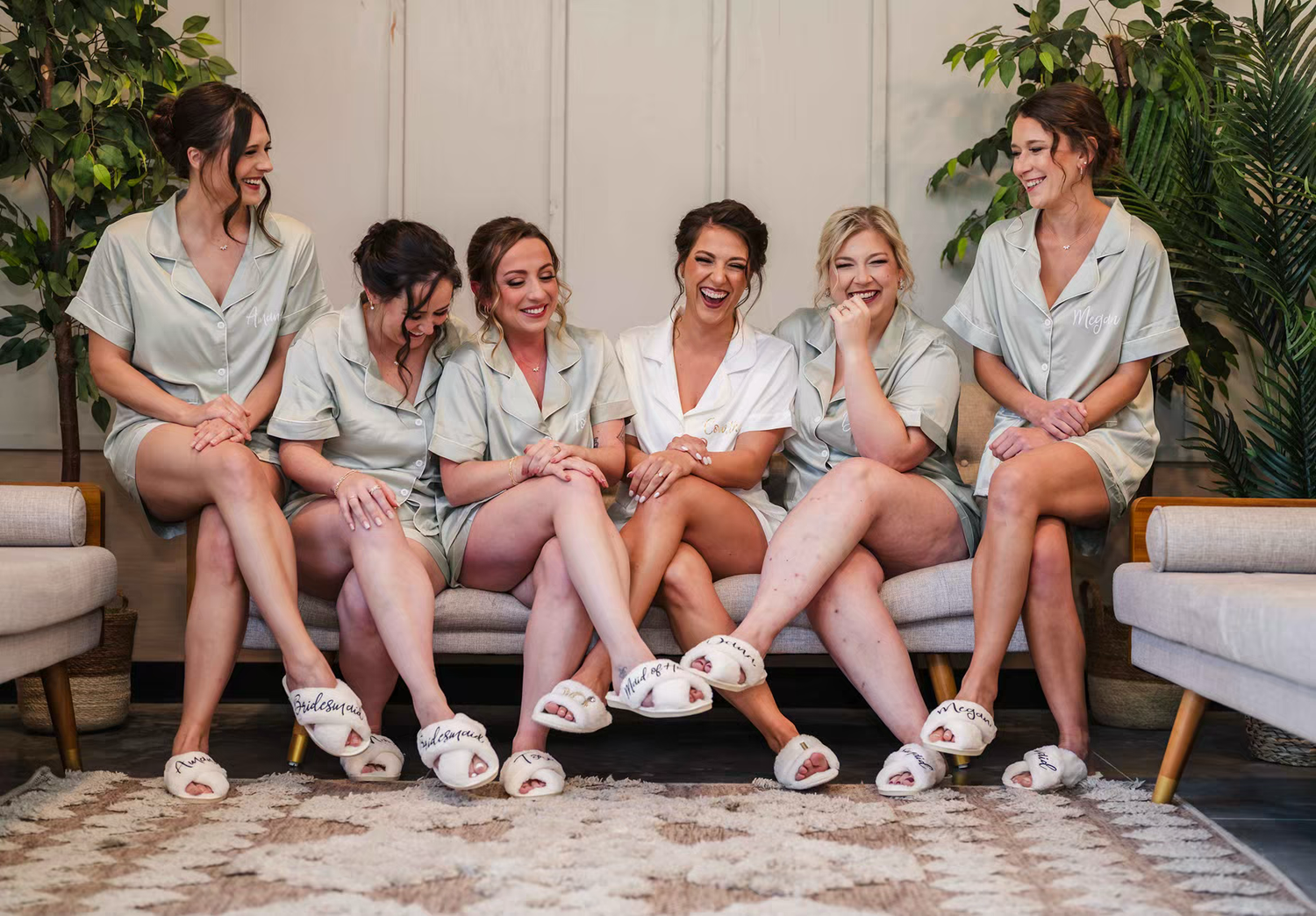 braidsmainds wearing matching white robes and slippers sits together in Retreat 21 Wedding Venue