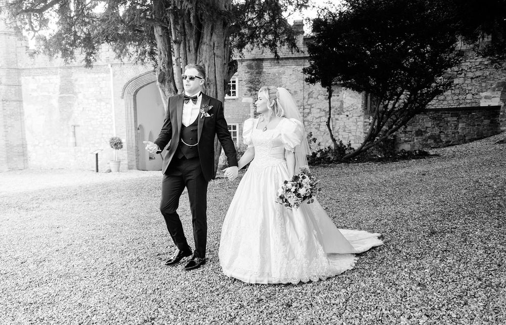 Black and white wedding photos arranged in a horizontal collage showing couples walking together outdoors.