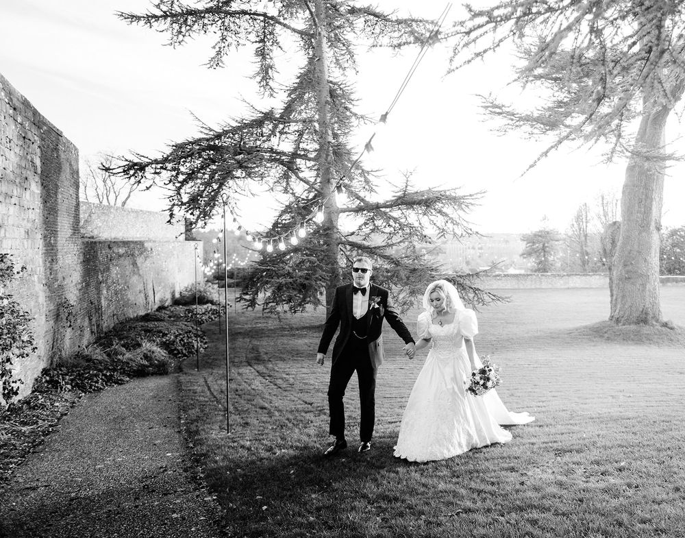 A romantic black and white wedding photo sequence shows a couple walking together through a misty garden setting.