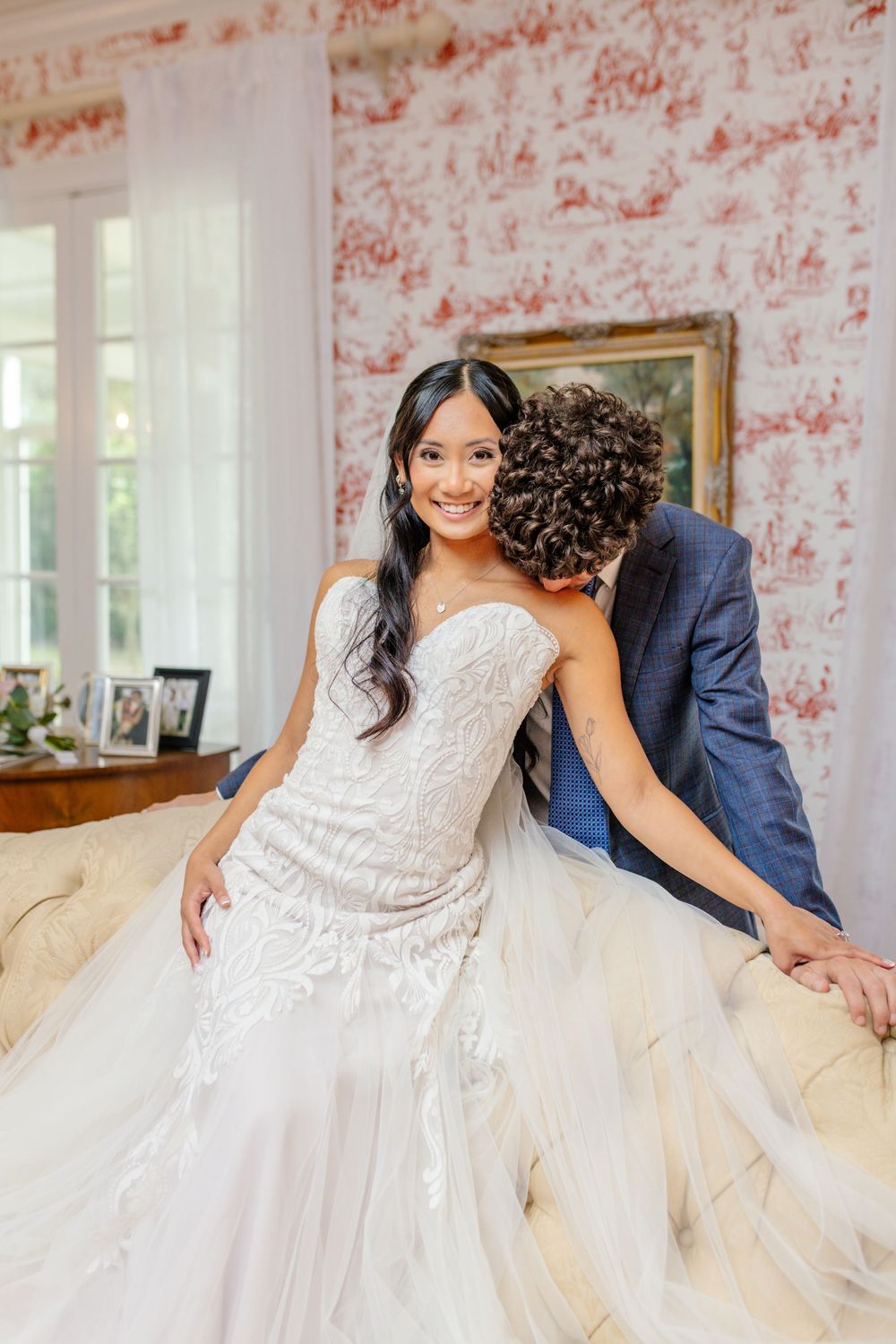 Romantic wedding couple shares intimate moment on an elegant tufted sofa.