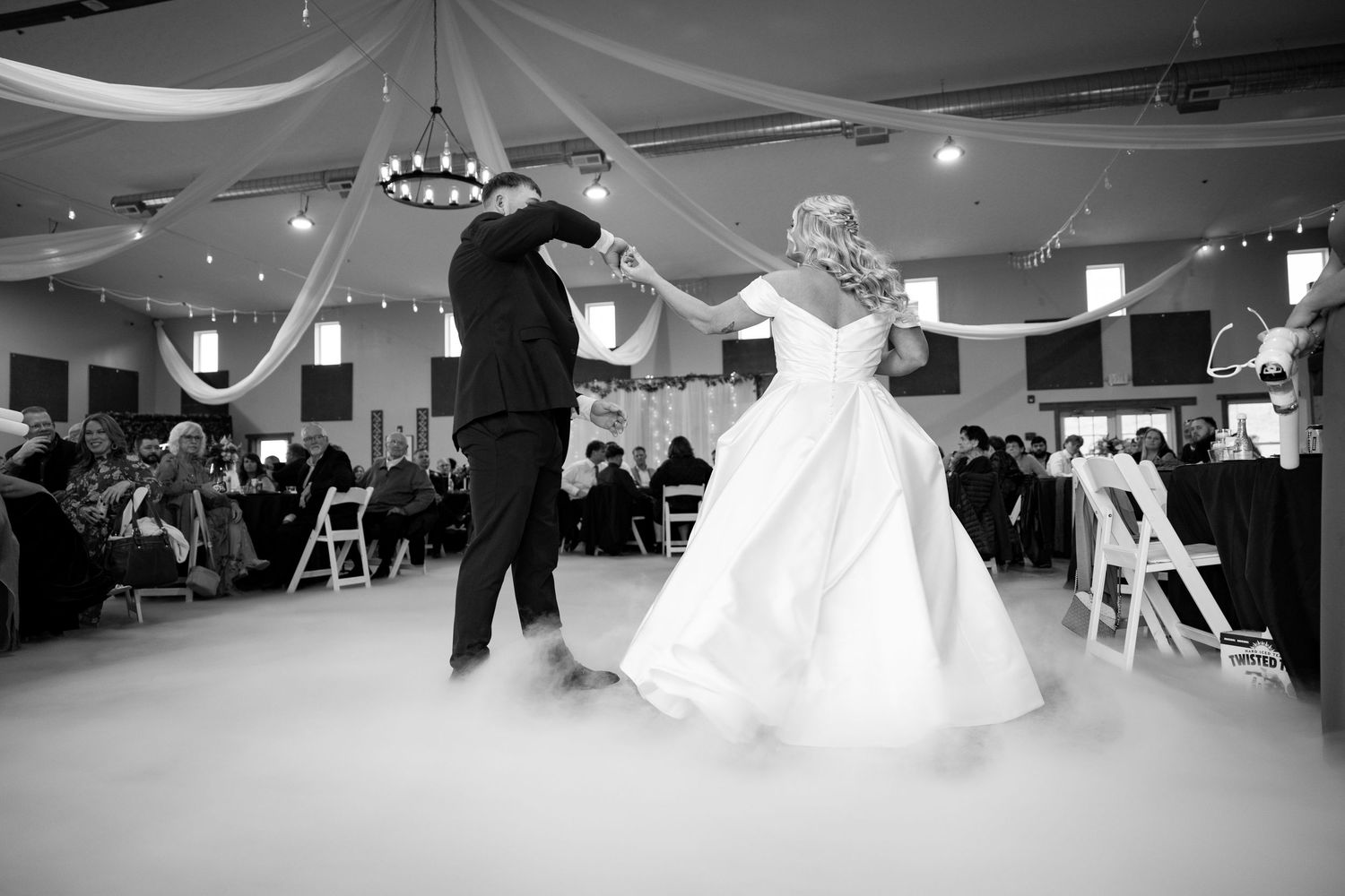 Dancers practice their moves in a spacious ballroom studio with white drapes and elegant lighting.