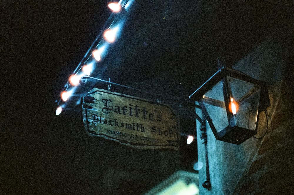 Vintage street sign and lantern illuminated at night.