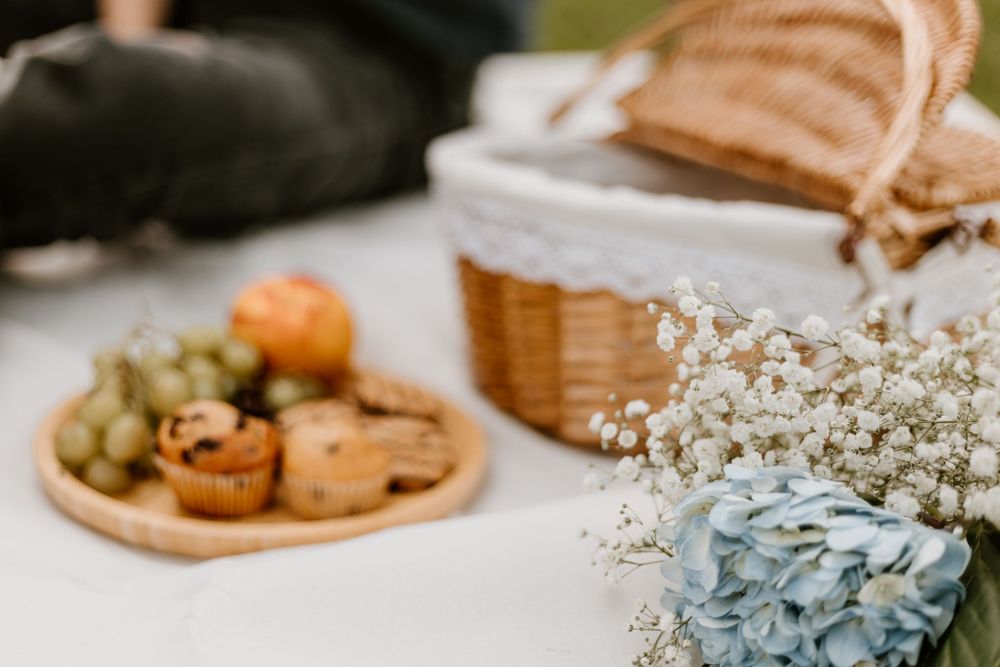 Table setting with pastries on wooden plate, bread basket and baby's breath flowers.