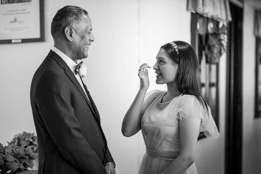 A touching pre-wedding moment between father and daughter shows joyful emotional reactions.