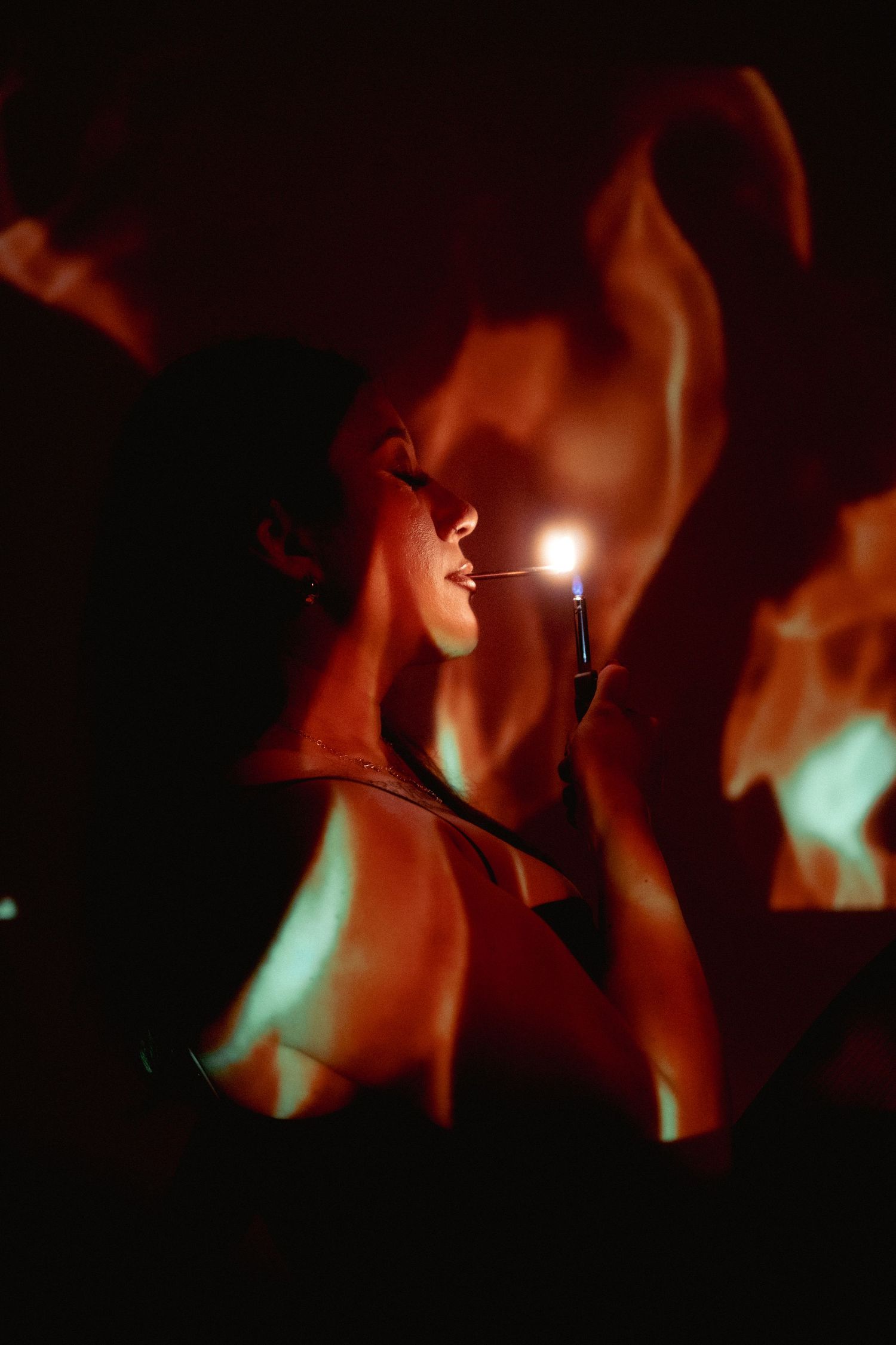 Atmospheric portrait with dramatic lighting and smoke effects against dark background.