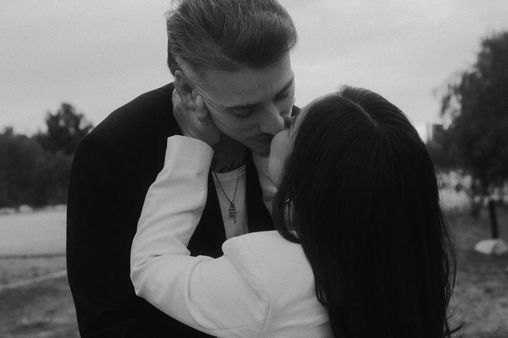 Romantic black and white photo of couple embracing outdoors.