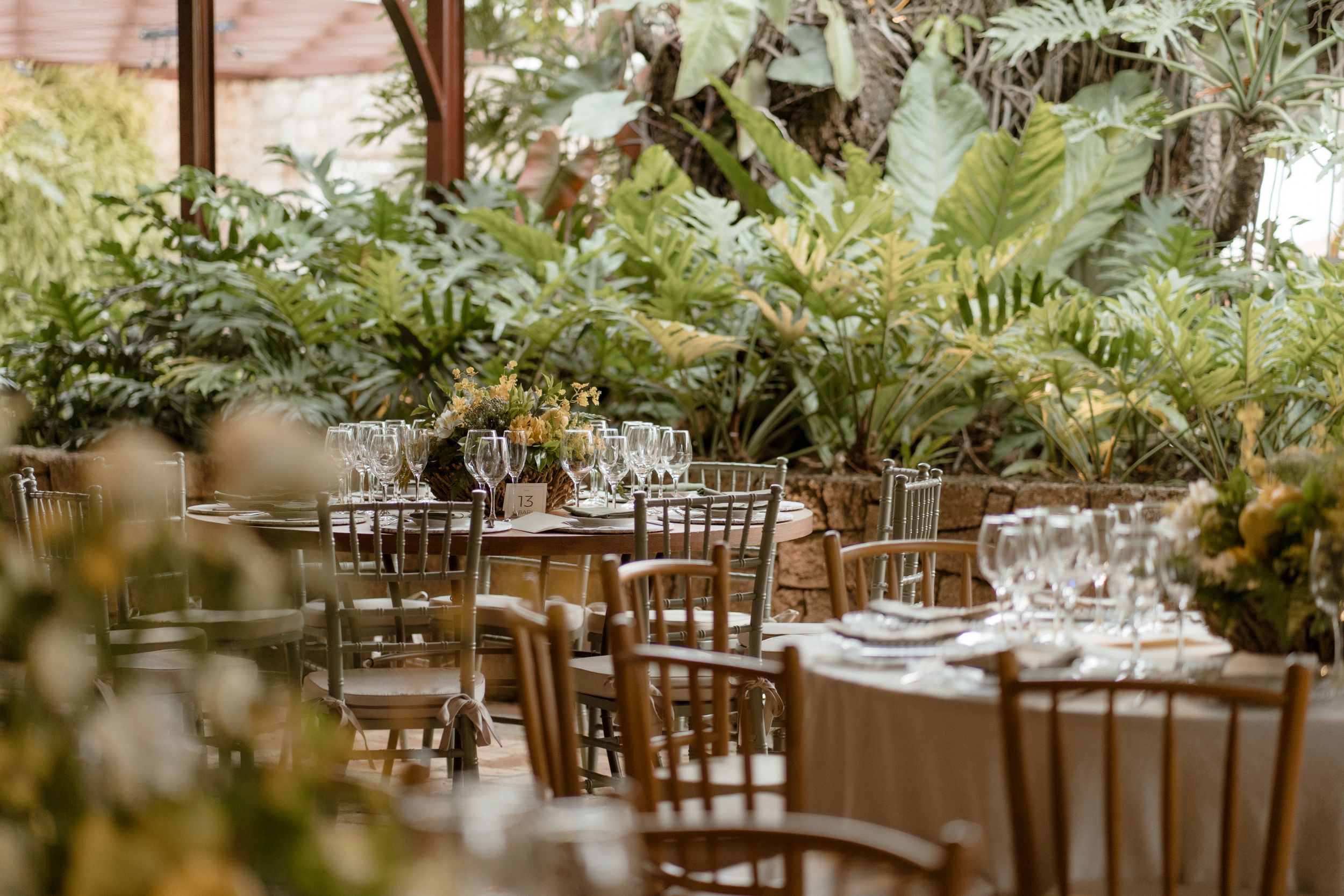 Elegant wedding reception tables with lush greenery and fern centerpieces.