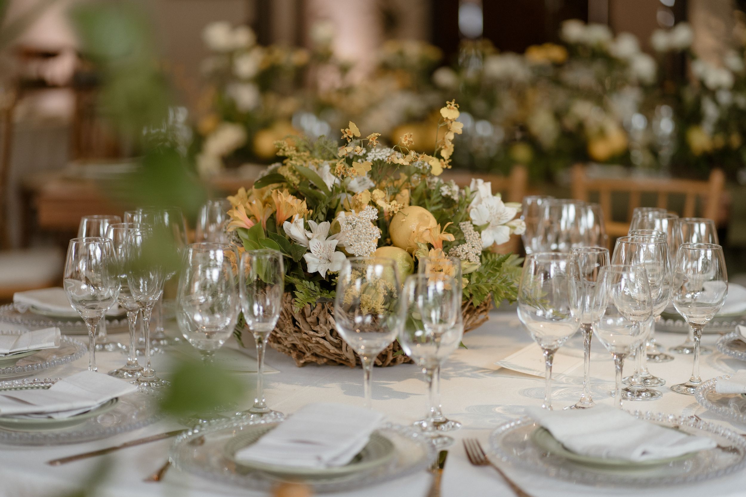 Formal table setting with delicate floral centerpiece and crystal glassware.