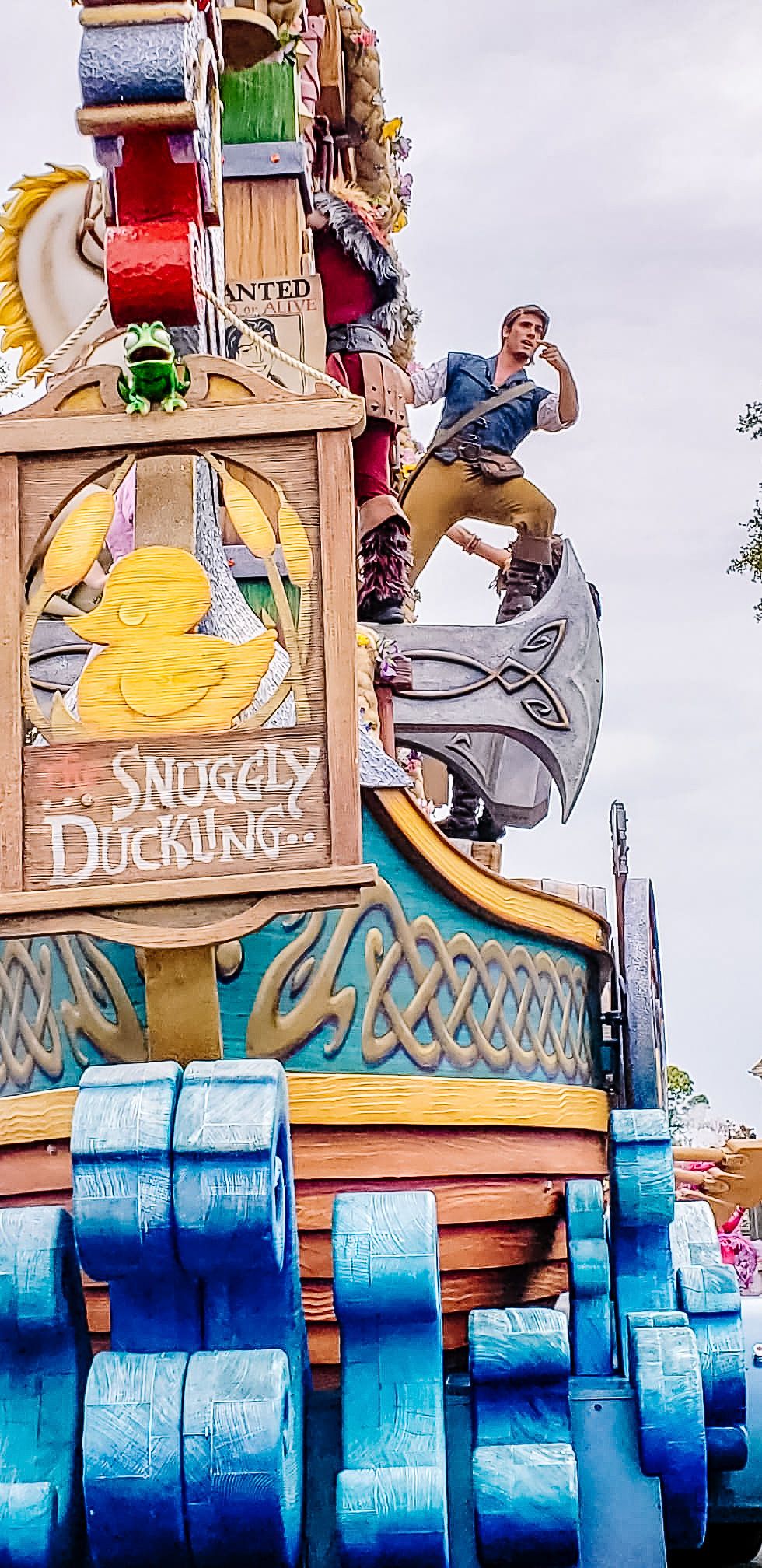 A colorful theme park attraction with 'Snuggly Duckling' signage and a person leaping across decorated structural elements.