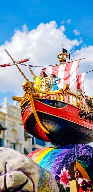Viking-style wooden ship float adorned with rainbow colors and striped sails in a vibrant Pride parade celebration.