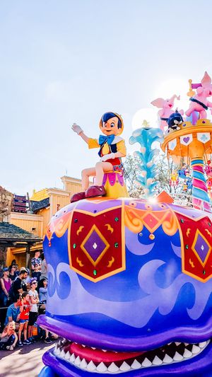 Pinocchio figure stands atop a colorful parade float featuring geometric patterns at Tokyo Disneyland's fantasy parade.