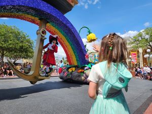 Eight photos merged together showing a colorful rainbow-decorated walkway arch at an outdoor festival or event.