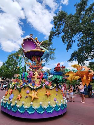 Colorful parade float featuring sea creatures, stars and whimsical designs at Disney World's Magic Kingdom theme park.