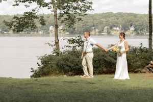 Wedding photos taken on a grassy lakeside with trees in the background.