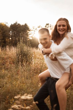 Joyful couple playing and spinning in a sun-lit field of wildflowers.