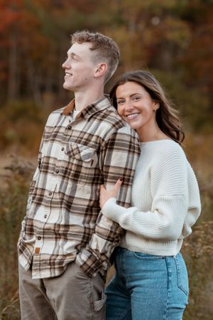 Couple enjoying playful moments together in outdoor fall setting.