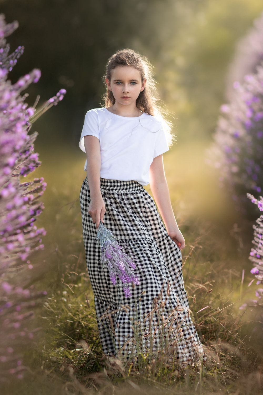 girl holding flowers in a Galena field during a family photo session, captured by Joplin family photographer.