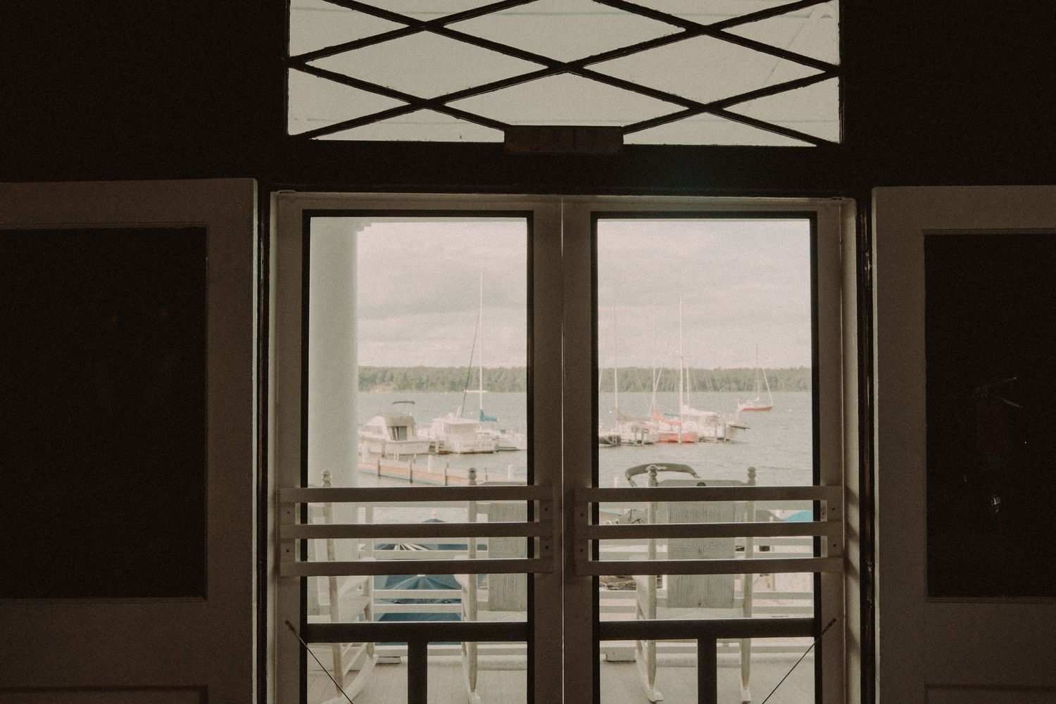 View of a marina through geometric-patterned windows in natural light.
