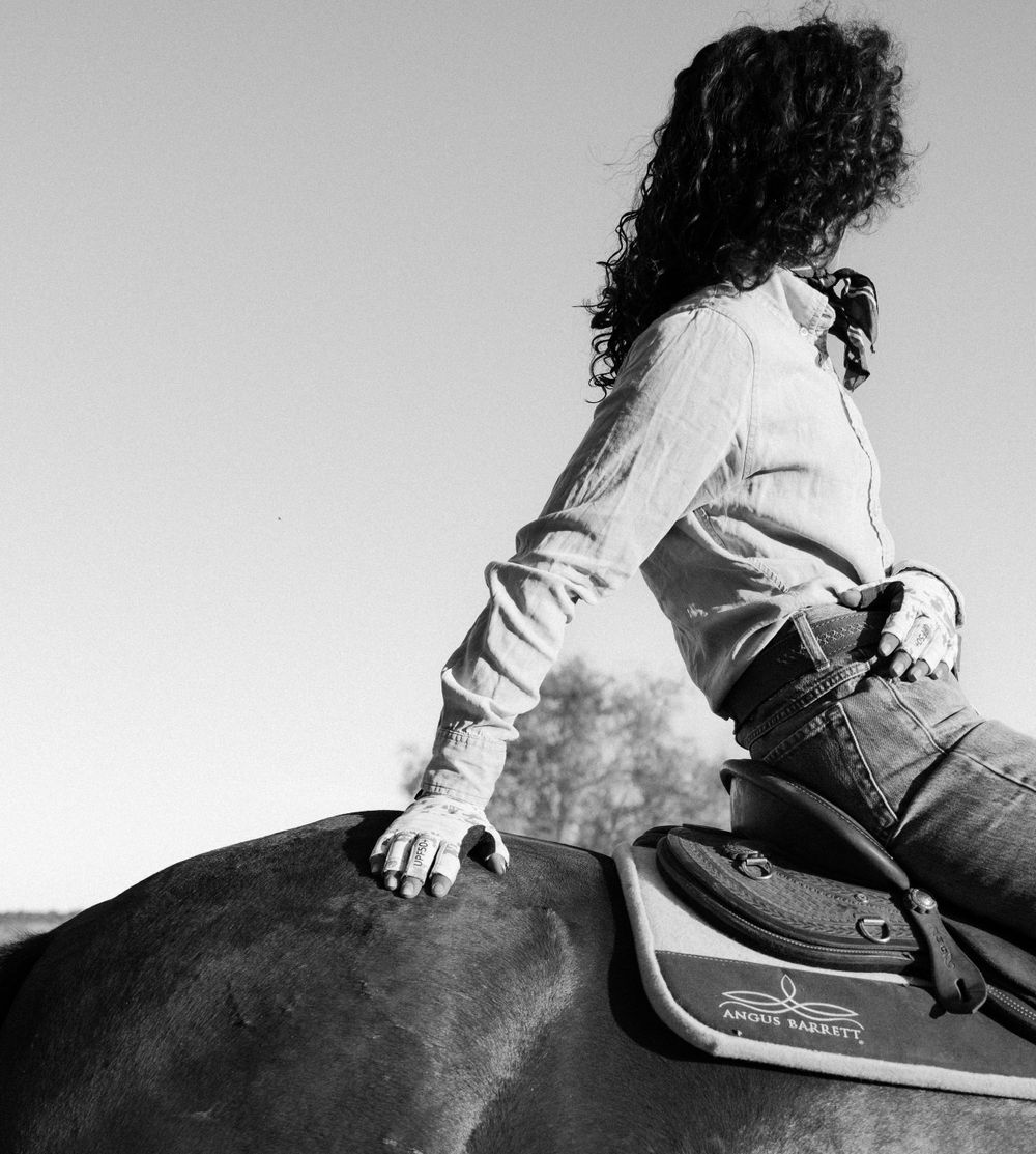 Black and white profile shot of rider mounted on horseback.