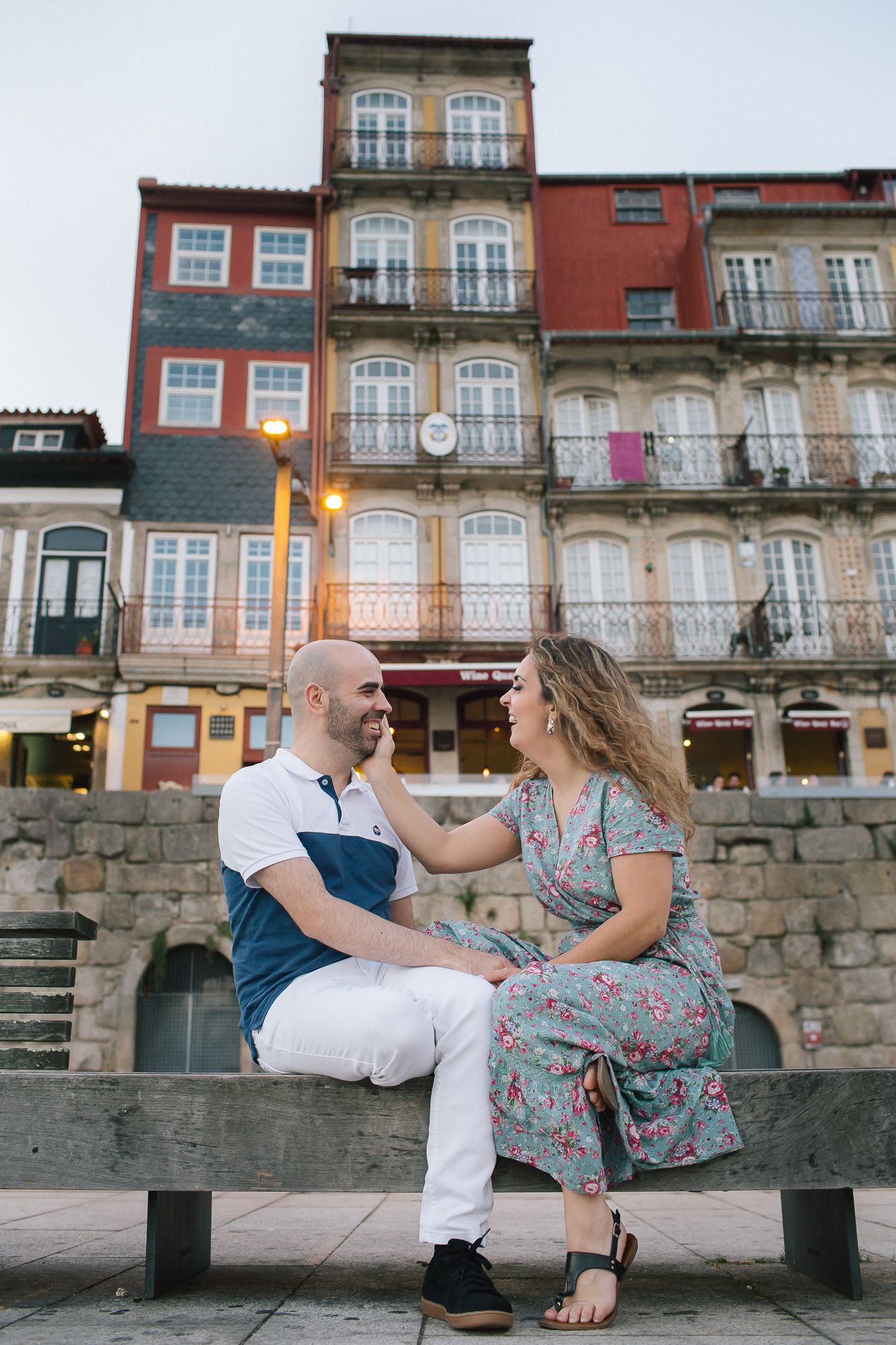 Casal namorados na ribeira do Porto sentados num banco de pedra