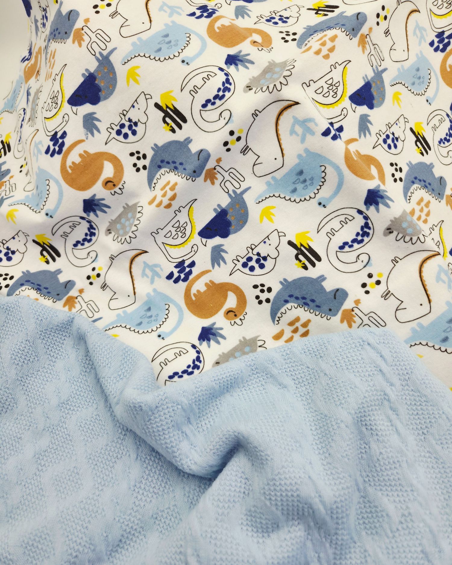 A blue and white floral pattern fabric with whimsical animal designs including bees and birds in soft pastel colors.