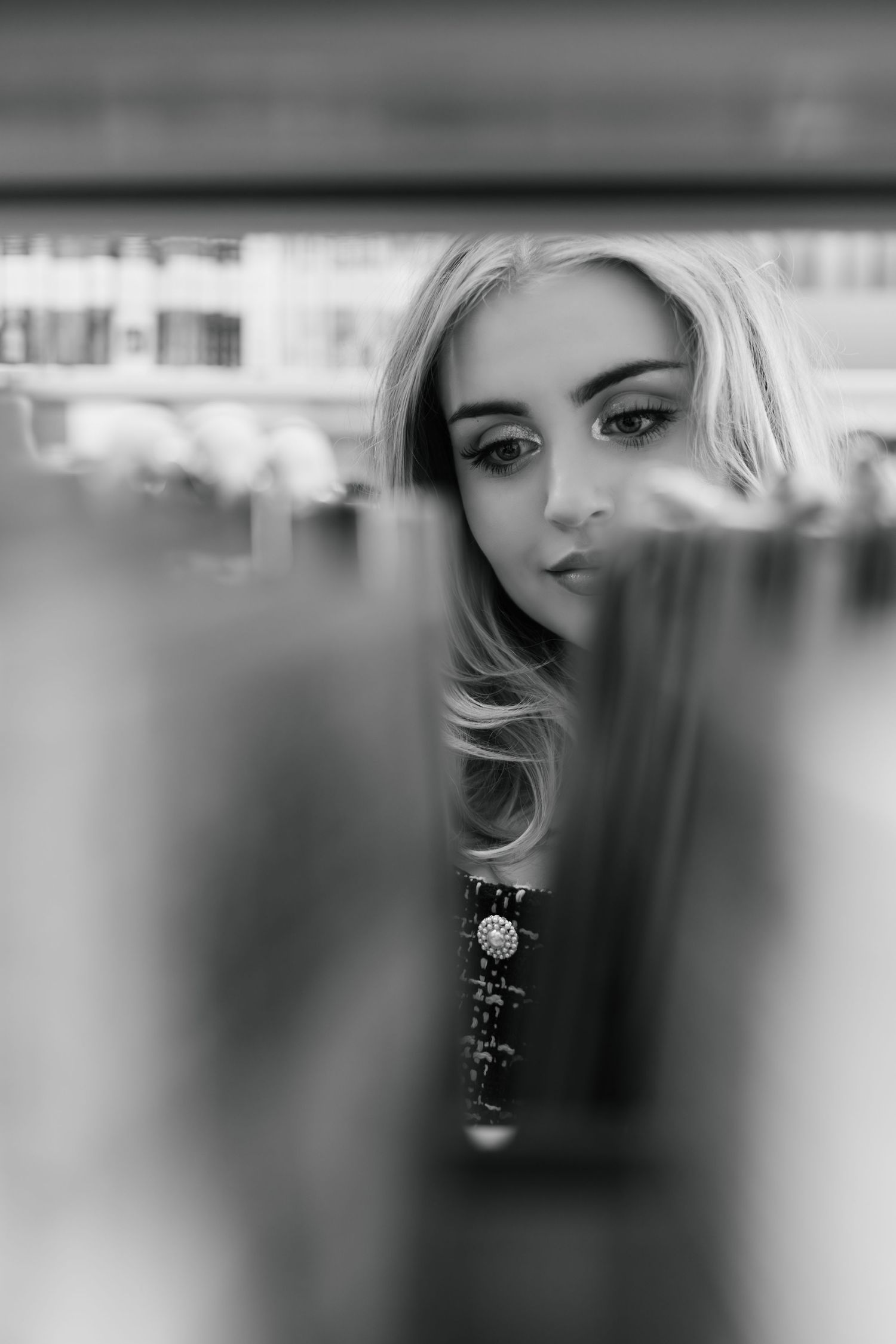 Black and white portrait photograph taken through glass showing a partially obscured reflective artistic composition.