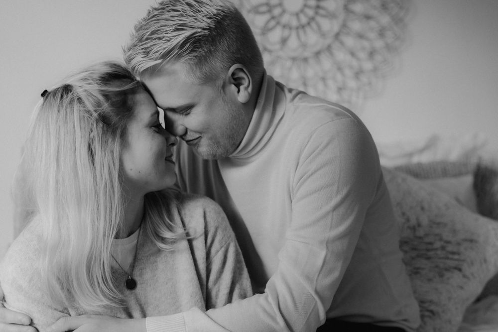 A romantic black and white intimate portrait of a couple sharing a tender moment together.