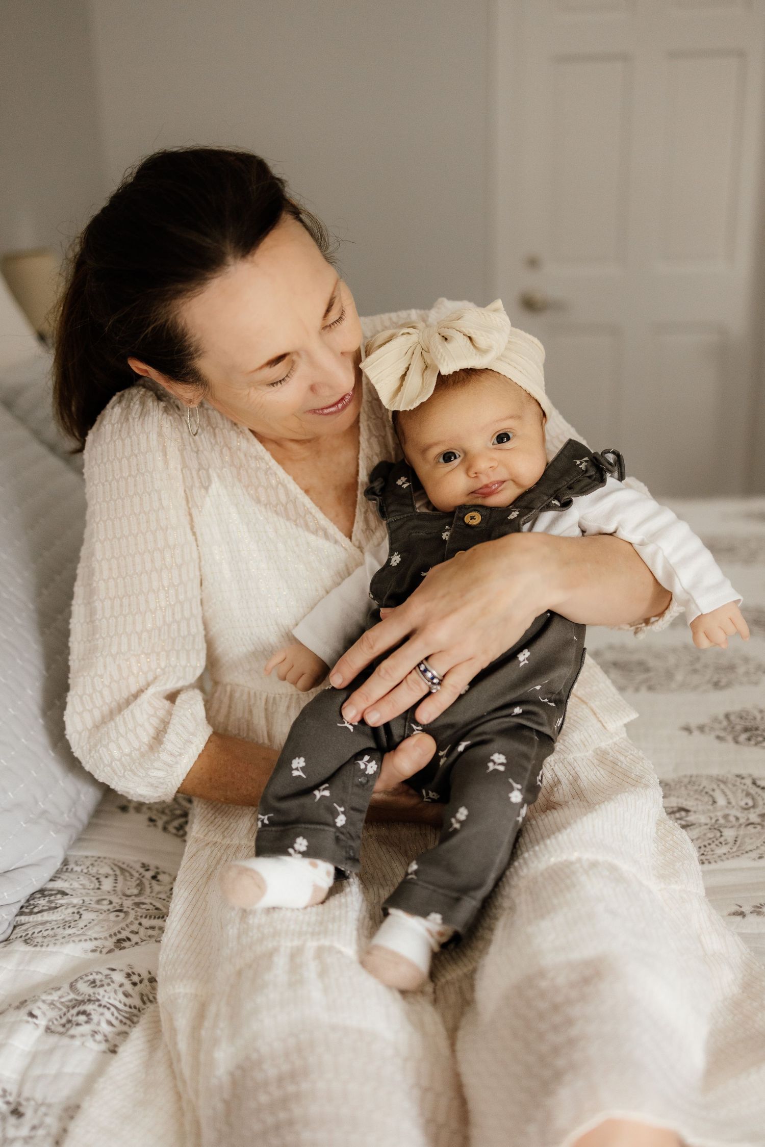 Grandmother holds newborn baby at in-home lifestyle newborn photoshoot in Los Gatos by Cindy Tucey Photography