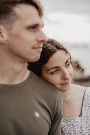 A close-up portrait of a couple in casual wear against a soft natural background.