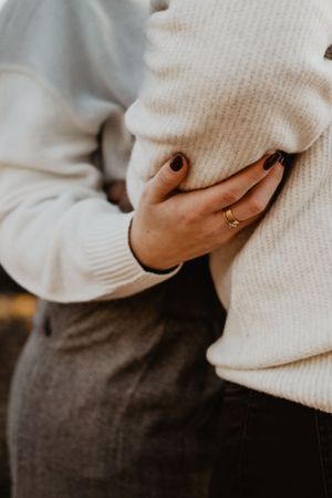 Photo lors d'une séance photo engagement. On voit le geste tendre de la main de la femme sur le bras de l'homme.