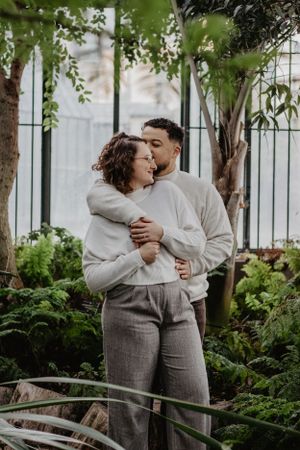 Photo d'un couple dans une serre à Lyon. L'homme embrasse la femme sur la joue