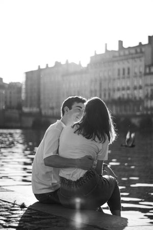 Photo en noir et blanc d'un couple au bord de la Saône. Il s'enlacent.