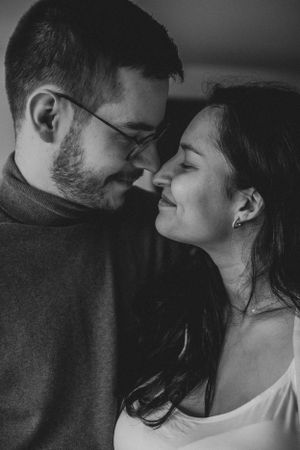 Photo en noir et blanc d'un couple amoureux. Leurs nez se touchent.