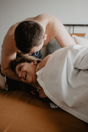 Photo d'un couple jouant ensemble. La femme rigole, l'homme chatouille la femme.