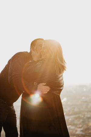 Photo d'un couple lors d'une séance en extérieur à Fourvière. Ils s'enlacent fougueusement sous le soleil