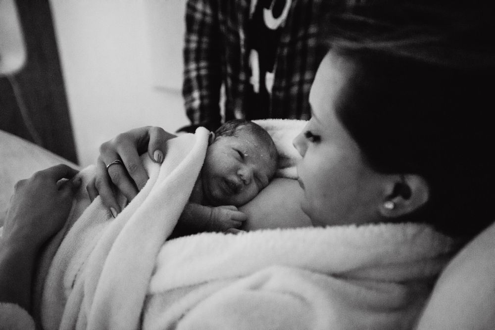 Intimate black and white portrait capturing tender moments during labor.