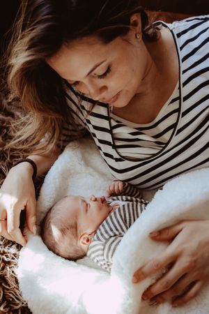 Peaceful moment showing nurturing care of a baby wrapped in soft white blankets.