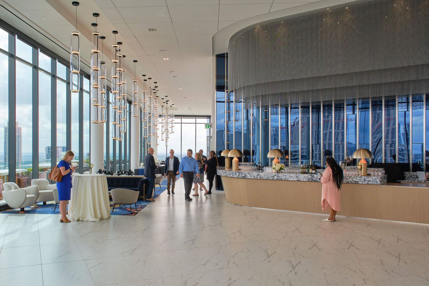 Modern lobby space with floor-to-ceiling windows and scattered cocktail tables.