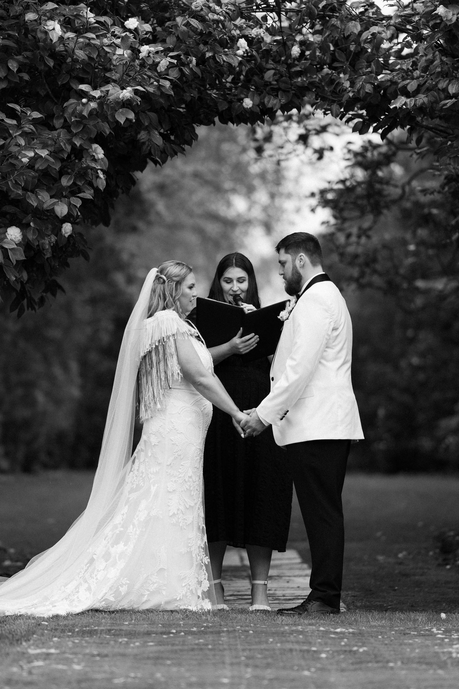 Black and white wedding photos showing couple in garden setting with trees and flowers.