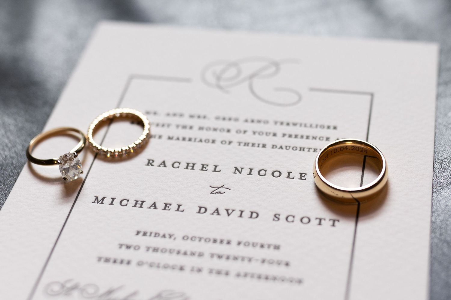 Wedding rings and elegant invitation details in soft gray tones.