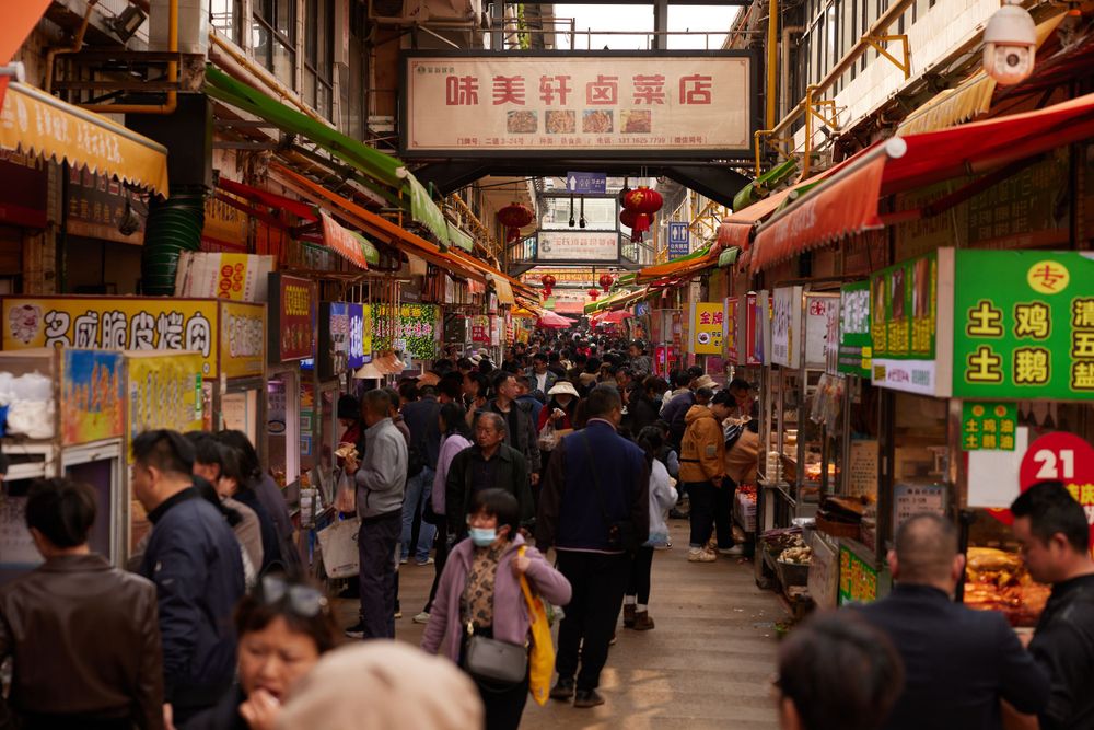 Crowded indoor market corridor with traditional Japanese shops and red awnings at Tsukiji Fish Market in Tokyo.
