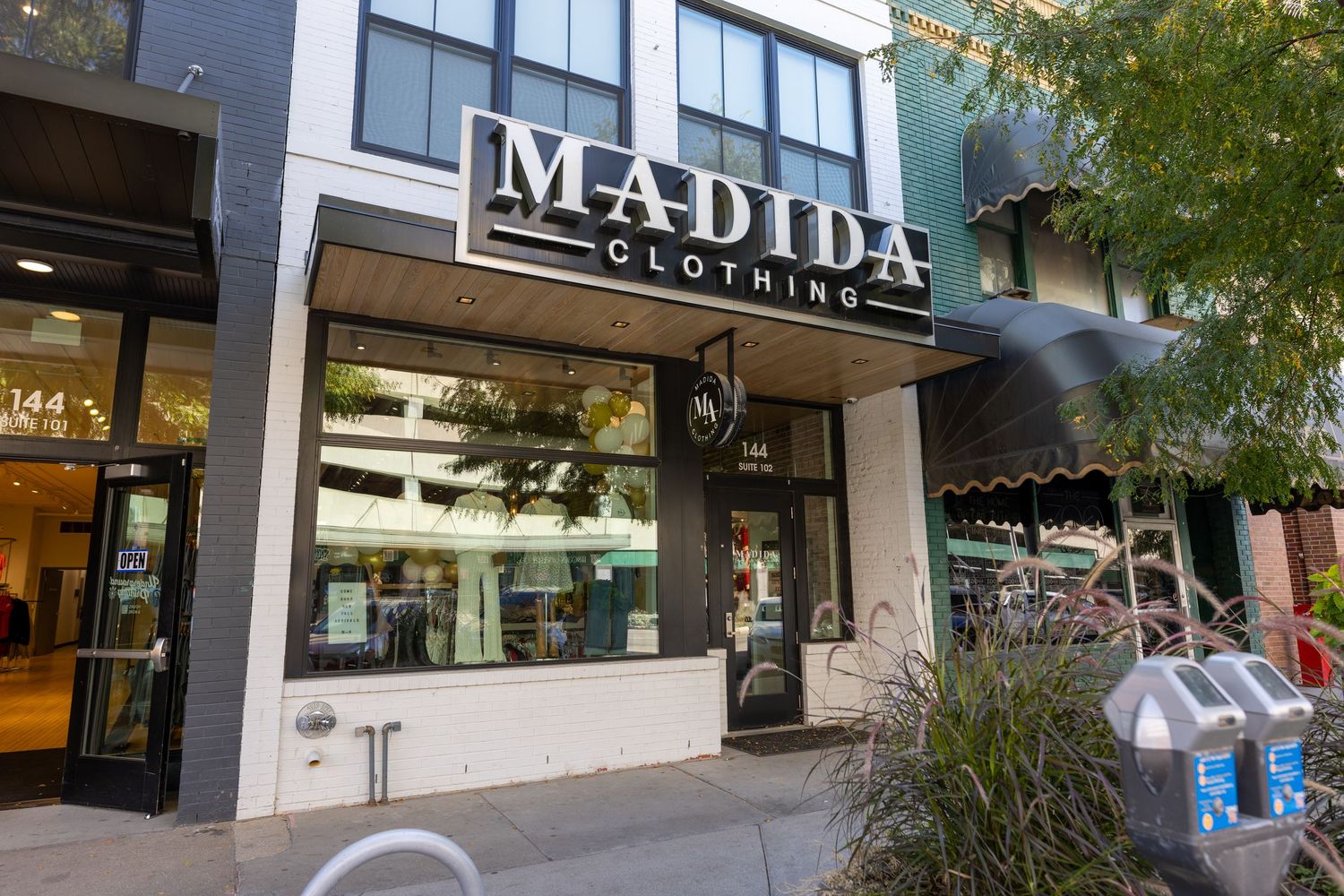 Street view of modern retail storefronts with 'Madina' signage visible.