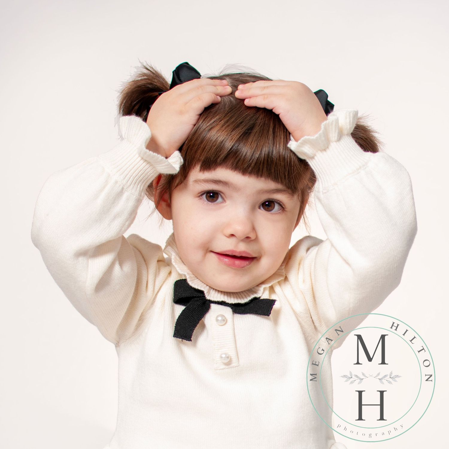 Toddler girl with her hands on her head