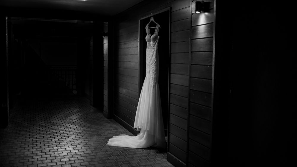 Wedding dress hanging in dark hallway with dramatic lighting and shadows.  Vancouver Island Whistler
