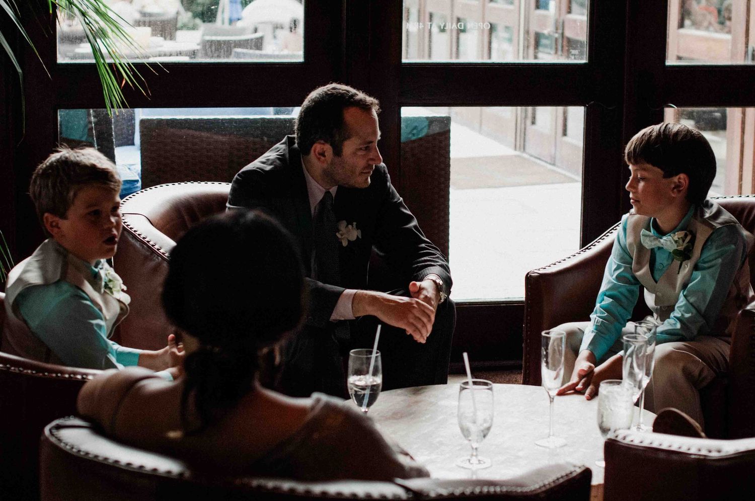 An informal gathering at a restaurant table with adults and children in conversation.